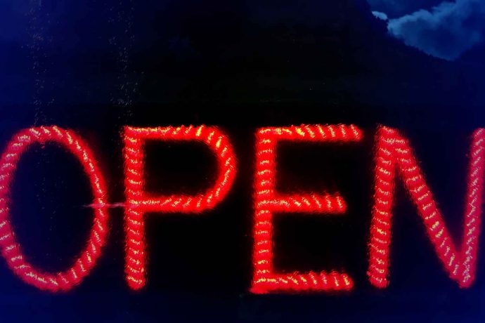 Foto Open Schild Neon LED Pop Art leuchtend auf schwarzem Hintergrund